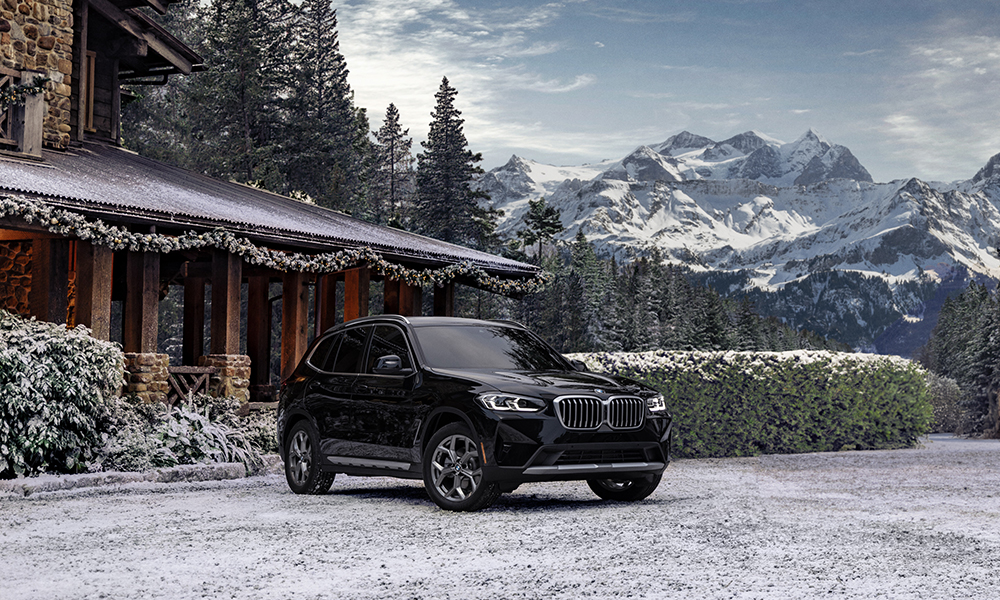 The 2024 BMW X3 xDrive30i parked in front of a festively decorated home