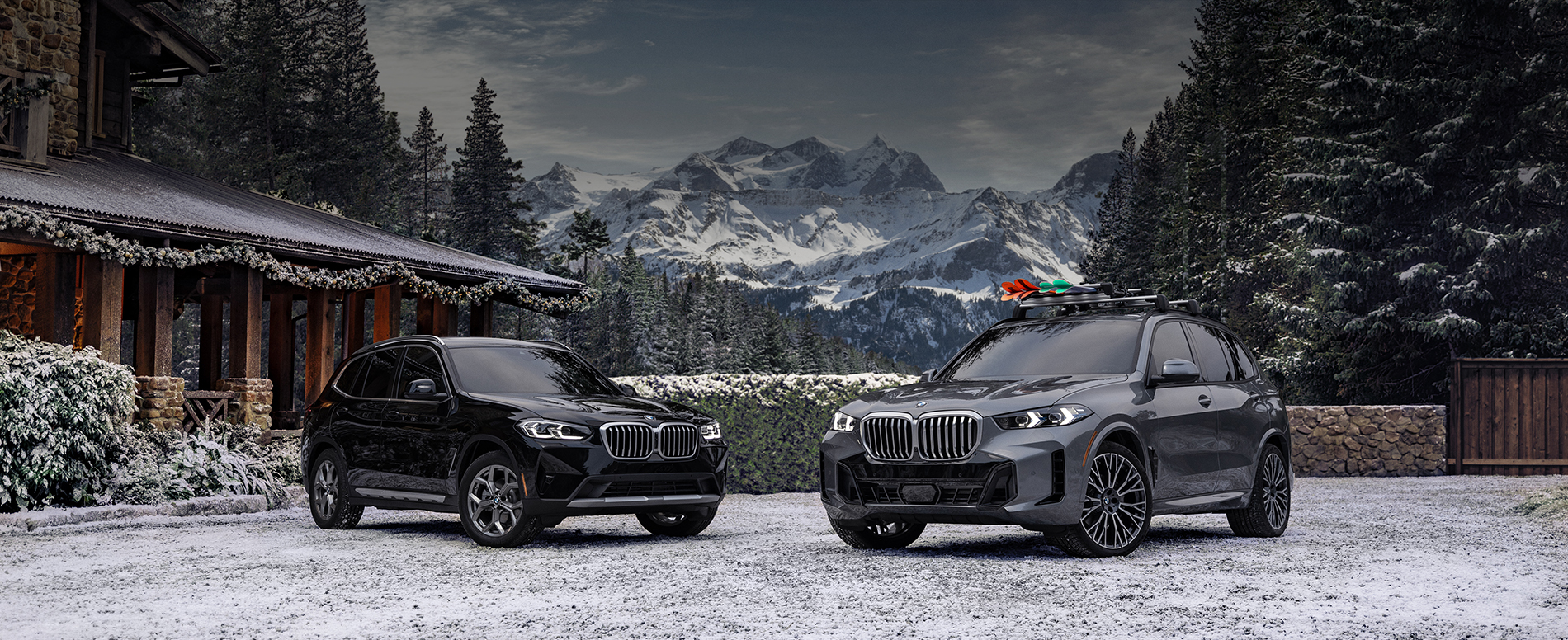 The 2024 X3 xDrive30i and the 2024 X5 xDrive40i with red and green skis perched atop, parked in front of a
    festively decorated home and wintry landscape.