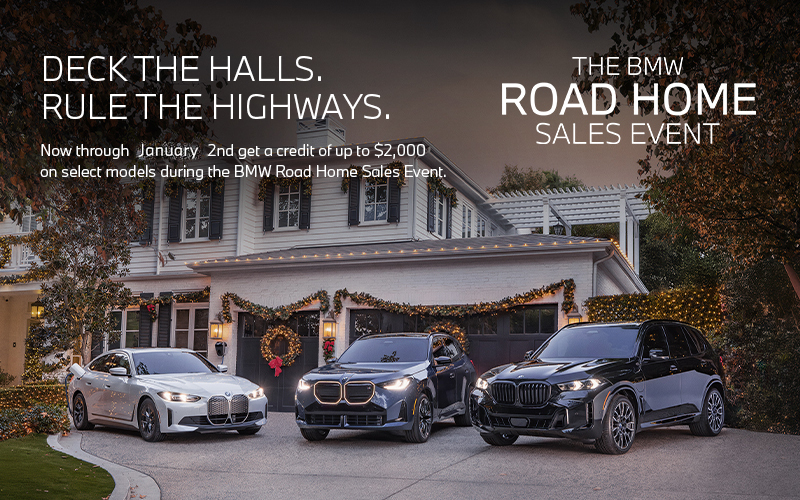 BMW i4, X3, and X5 parked in a driveway of a holiday decorated home.