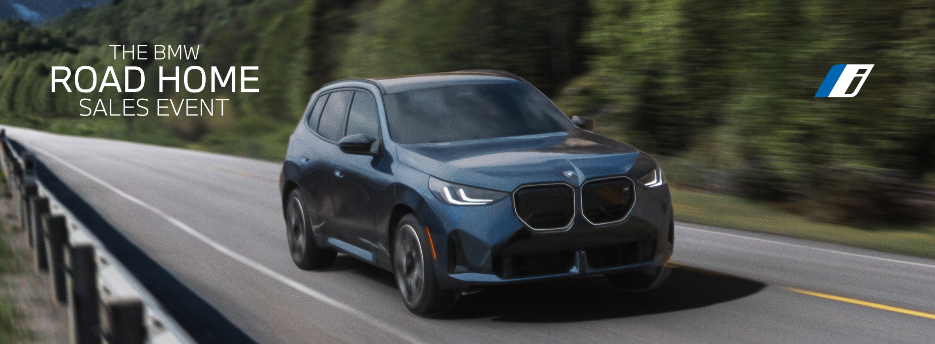 The BMW X3 M50 driving around a mountainous curve.  