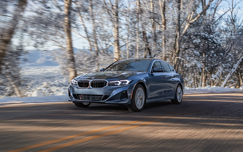 BMW 3 series driving on a road.