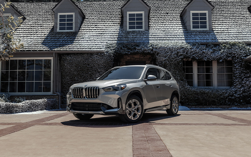BMW X1 series parked next to a house.