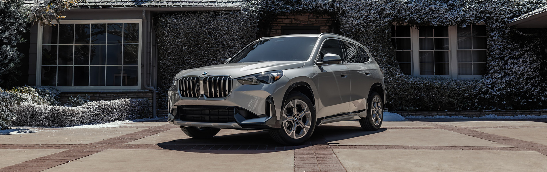 BMW X1 series parked next to a house.