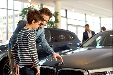 A father and son checkout a vehicle inside a BMW showroom