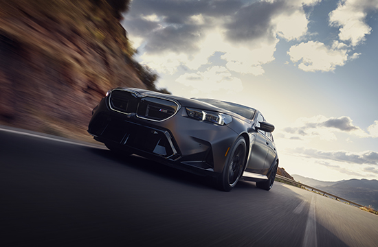 New BMW M5 Sedan driving on road front shot.