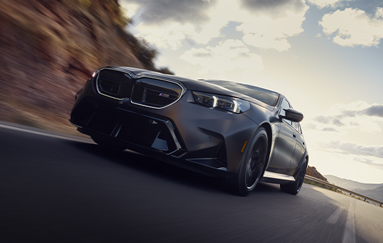 New BMW M5 Sedan driving on road front shot.