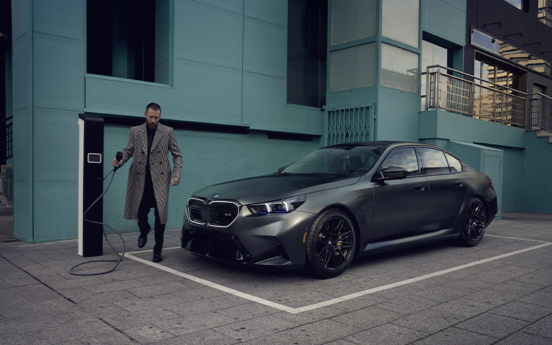 Man charging BMW M5.