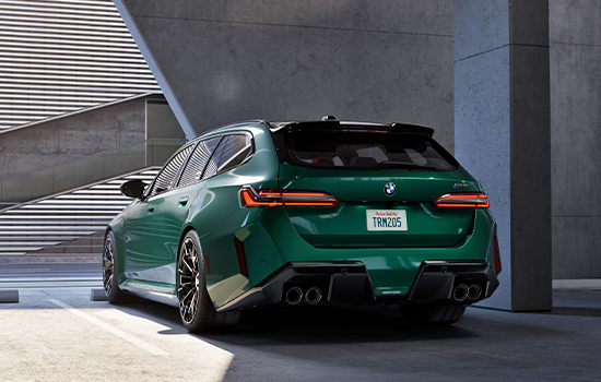 Green BMW M5 Touring parked in garage.