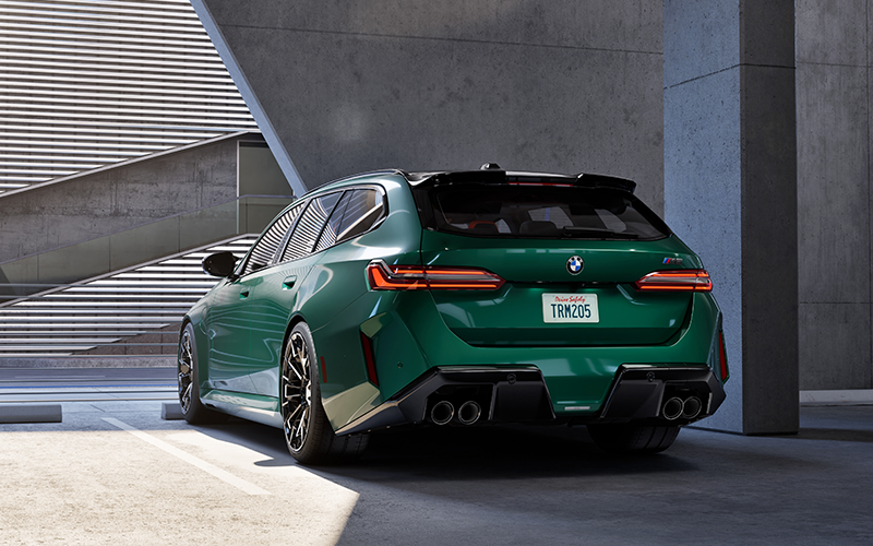 Green BMW M5 Touring parked in garage.