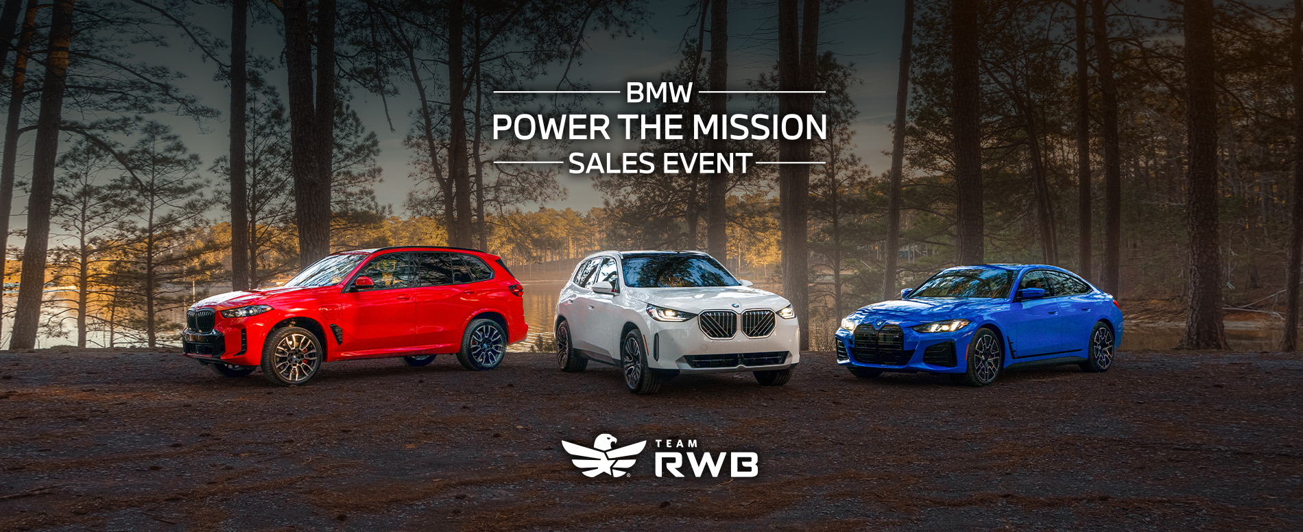 Red white and blue BMW parked with a forest landscape.