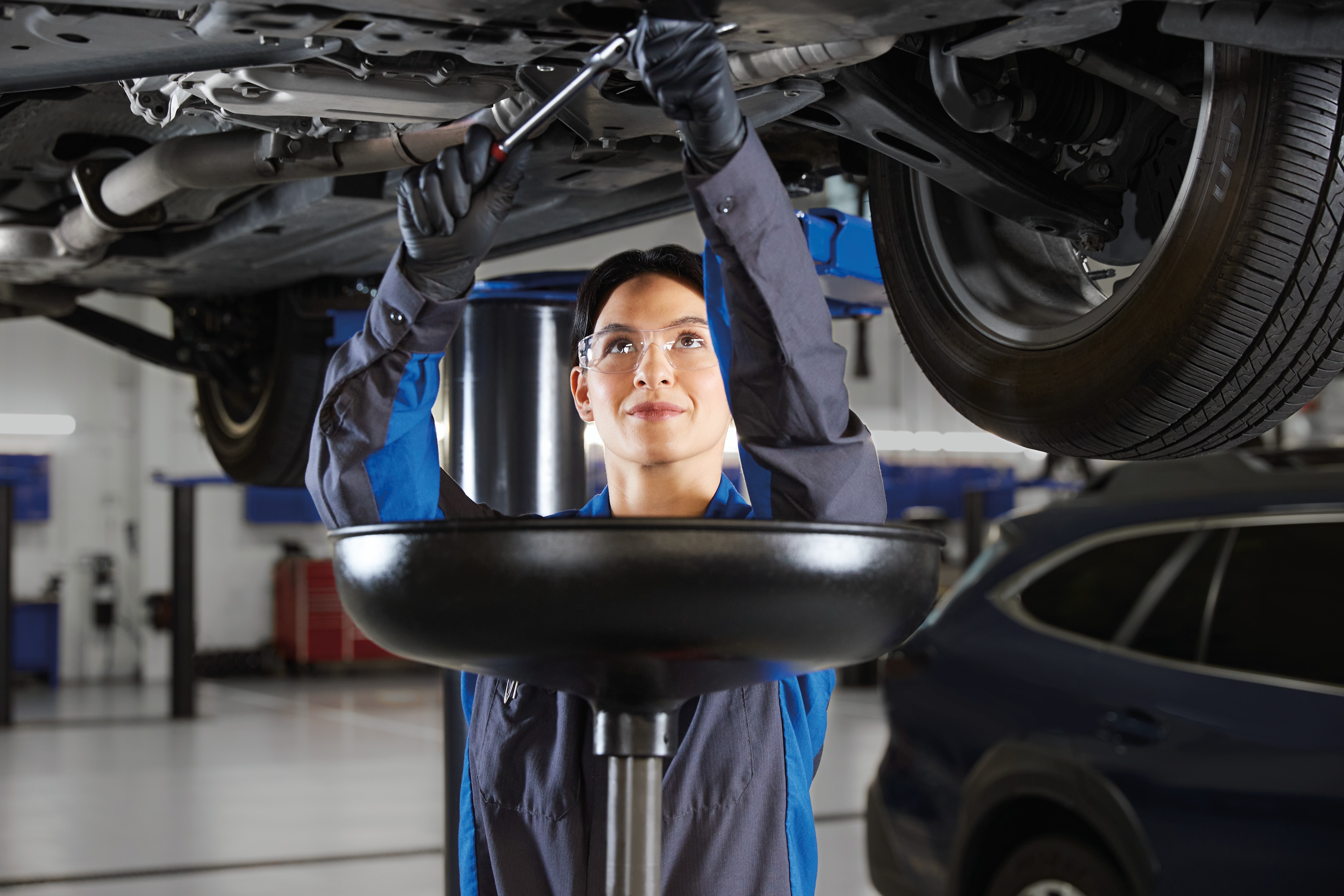 A Subaru service technician checking an oil dip stick.
