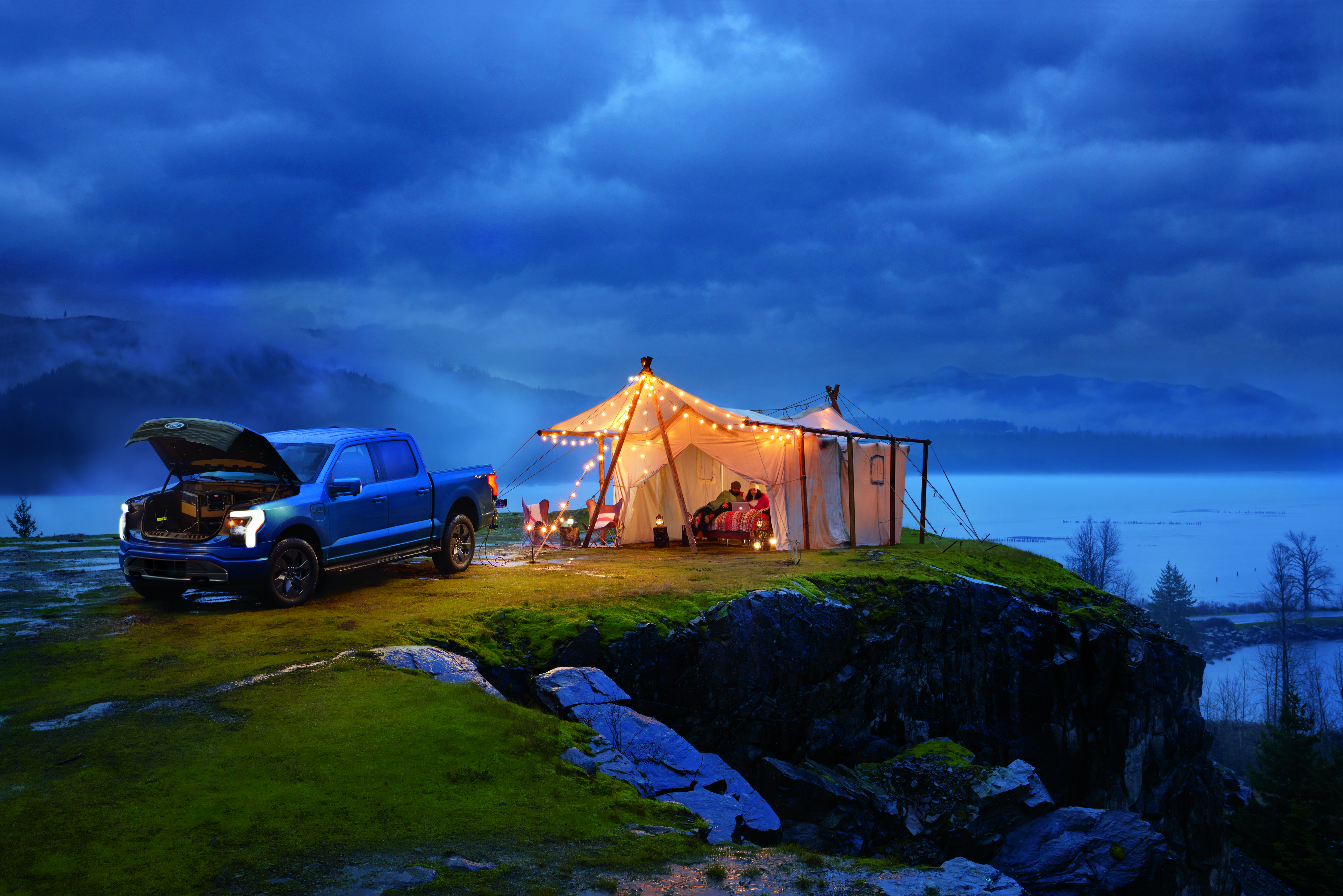 A F-150 Lightning® outside powering the lights at a campsite.