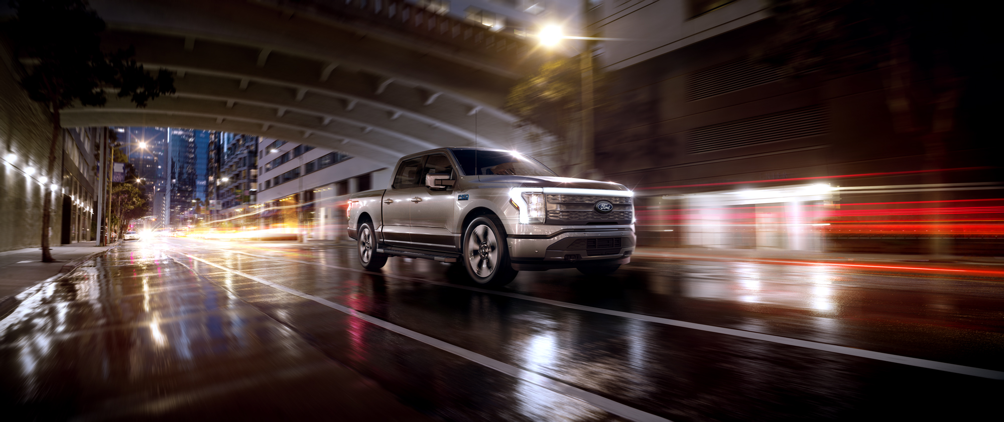 An F-150 Lightning® being driven in the city at night