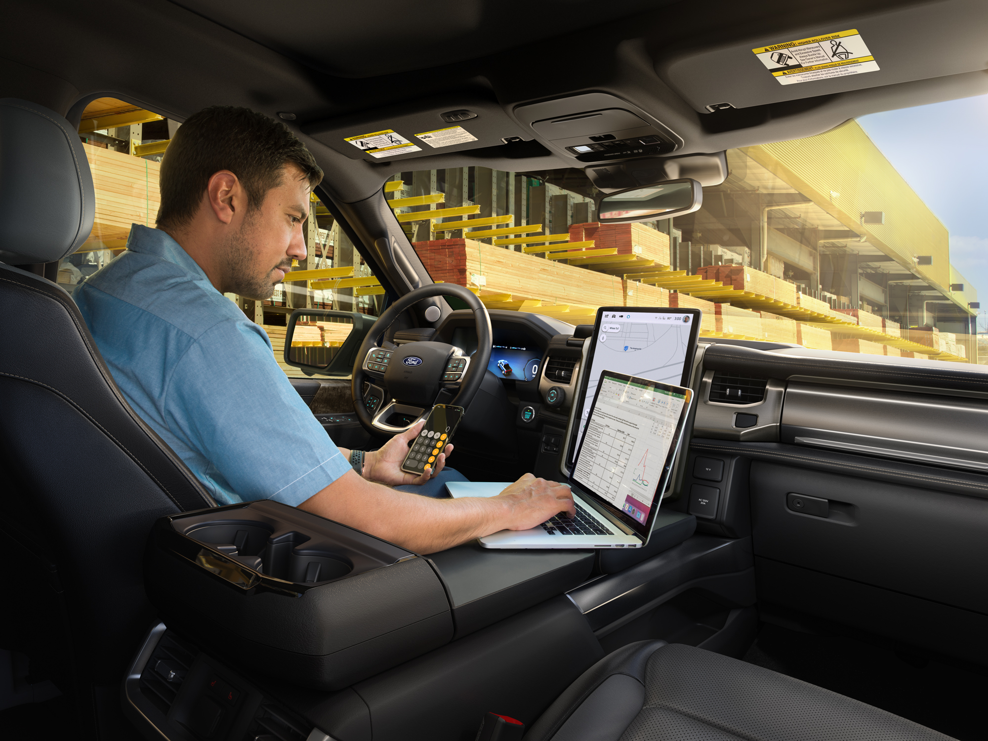 A man in his F-150 Lightning® working on a laptop.