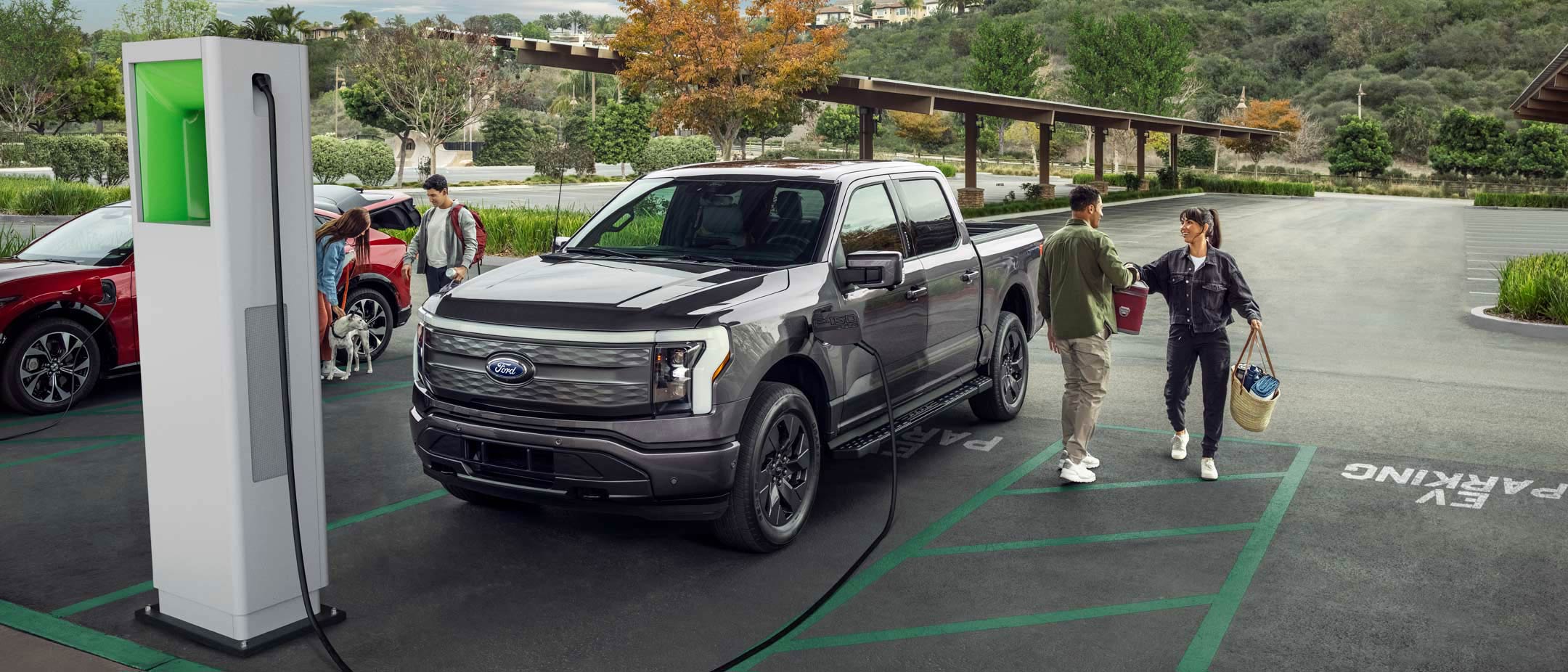 A man and woman unload an F-150 Lightning® at a public charging station