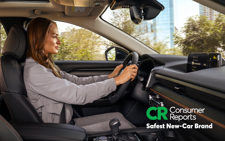 Driver inside a Mazda with Consumer Reports Safest New-Car Brand badge