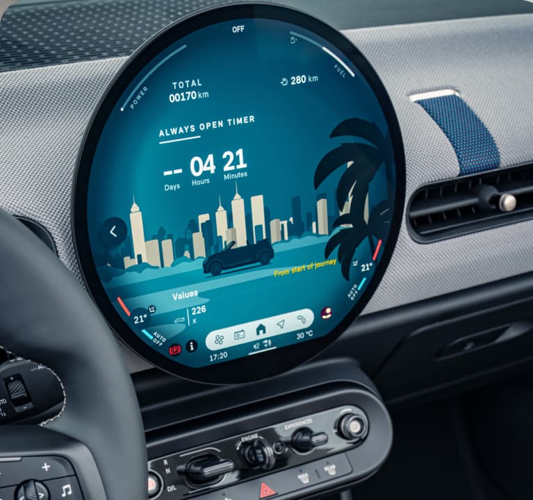 A close-up of the MINI Head-up Display
        with parts of the steering wheel and MINI OLED
        Display visible.