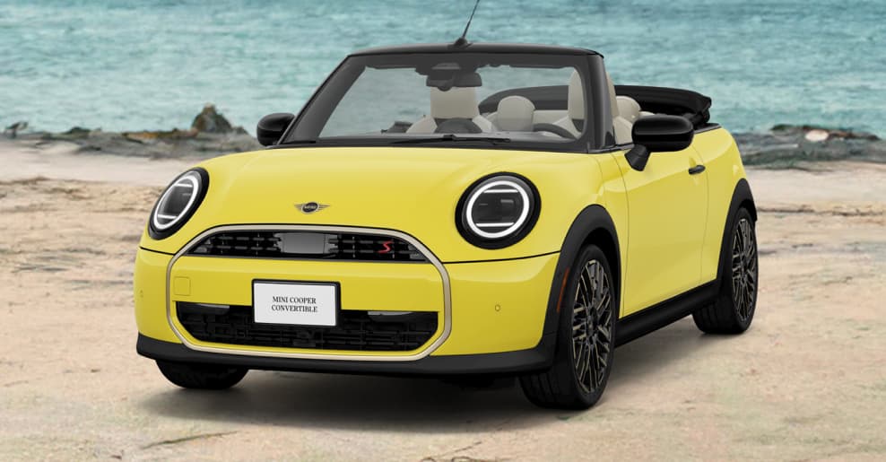 Front view of yellow MINI Cooper Convertible parked on the beach.