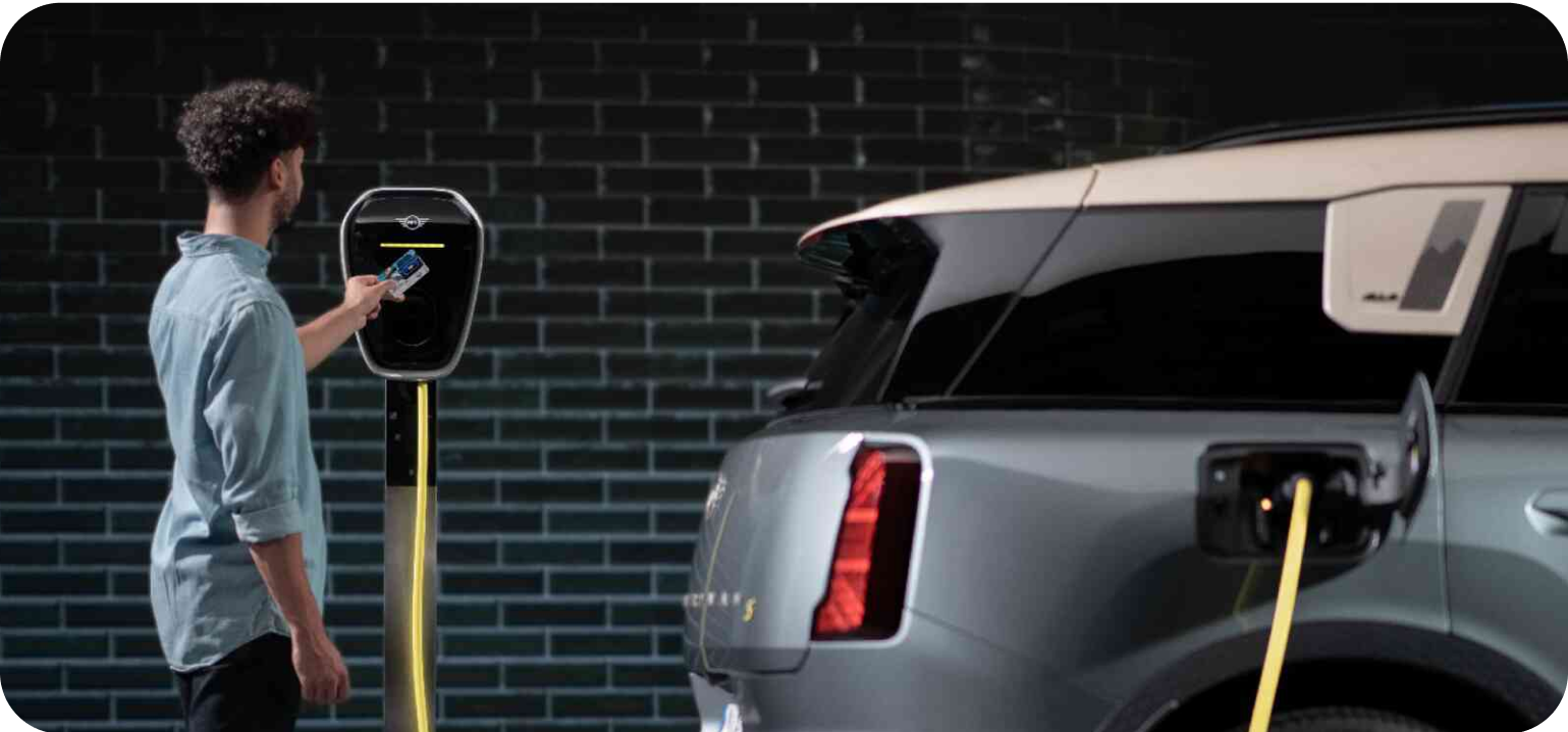 A man charges his MINI Countryman SE ALL4 using a MINI Wallbox