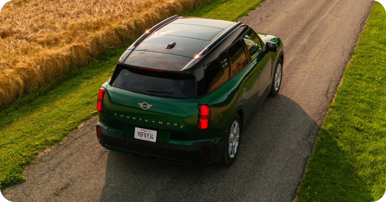 Bird’s-eye view of the MINI Countryman SE ALL4 driving down a road.