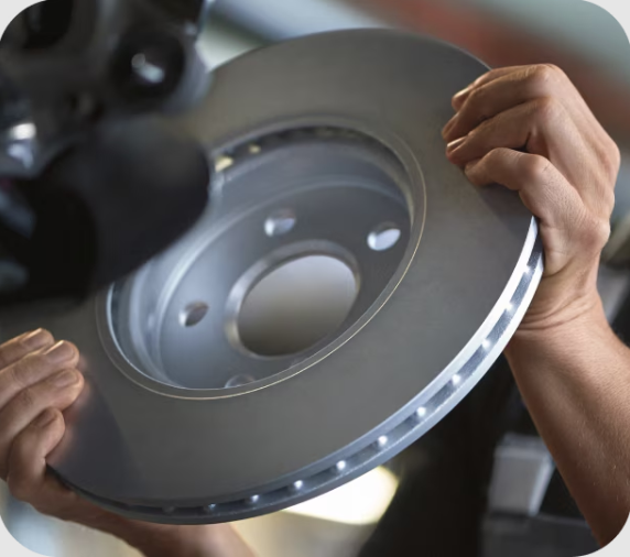 Closeup view of hands holding a circular piece  of metal with the background blurred out