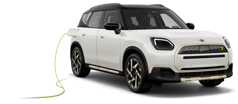 Angled view of a white MINI Cooper SE Electric Hardtop 2 Door and MINI Countryman SE ALL4 parked next to each other against a white brick background.