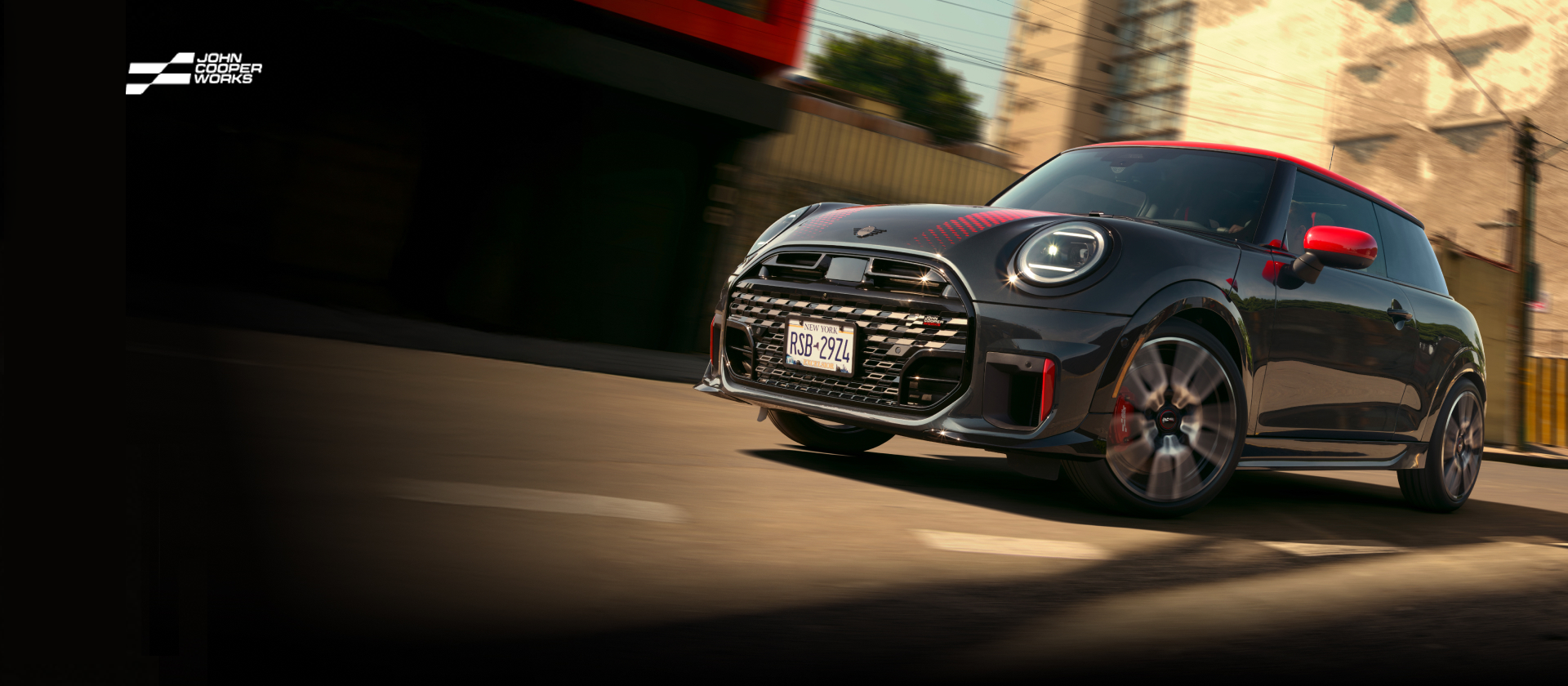 A MINI JCW 2 Door cruising down a street.