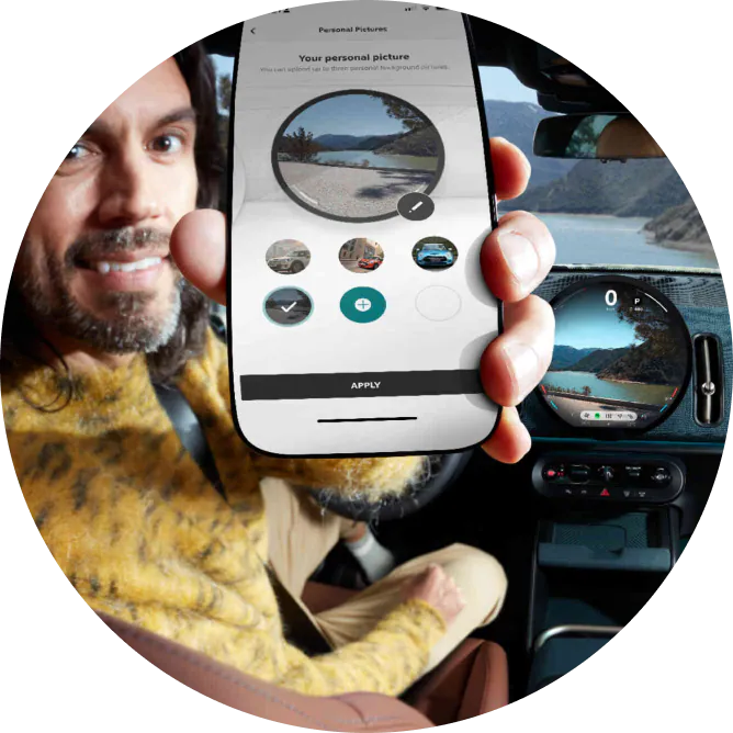 A man holding up his phone with the MINI App open on the screen.