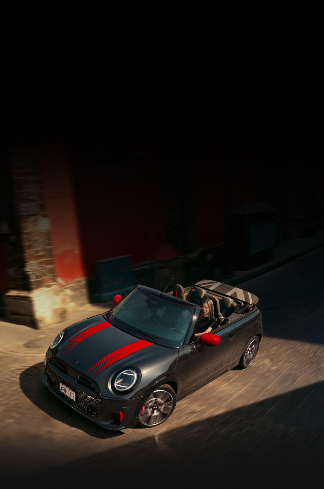 The MINI JCW Convertible rounding a bend.