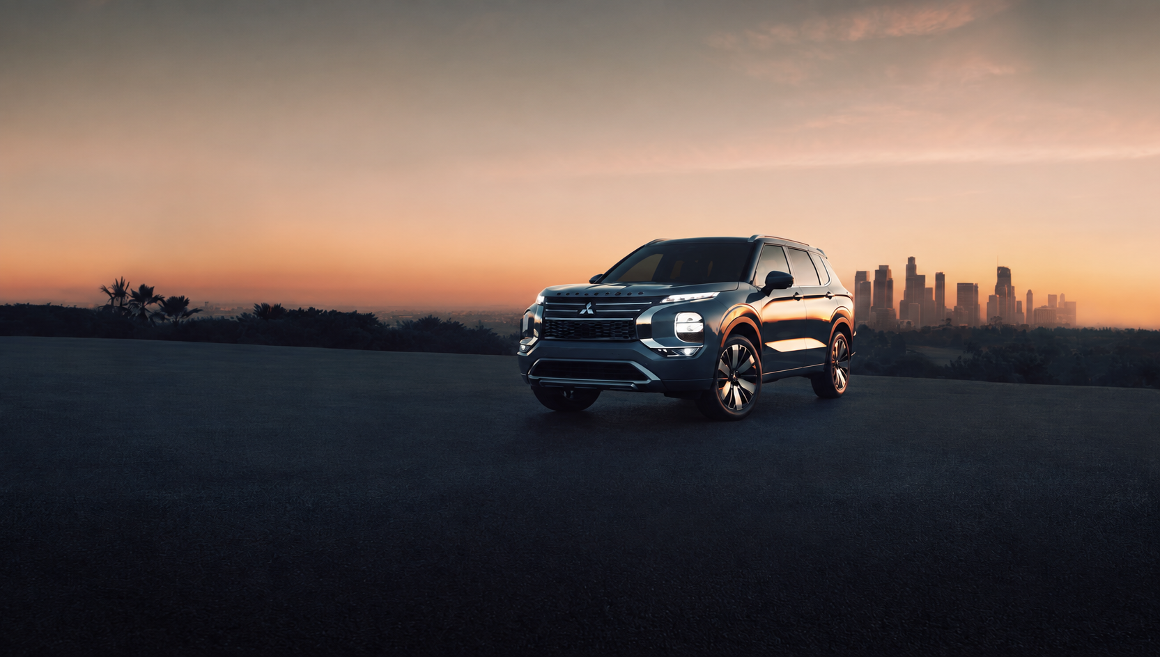 Sunset image of the 2026 Outlander on a cliff with a city background