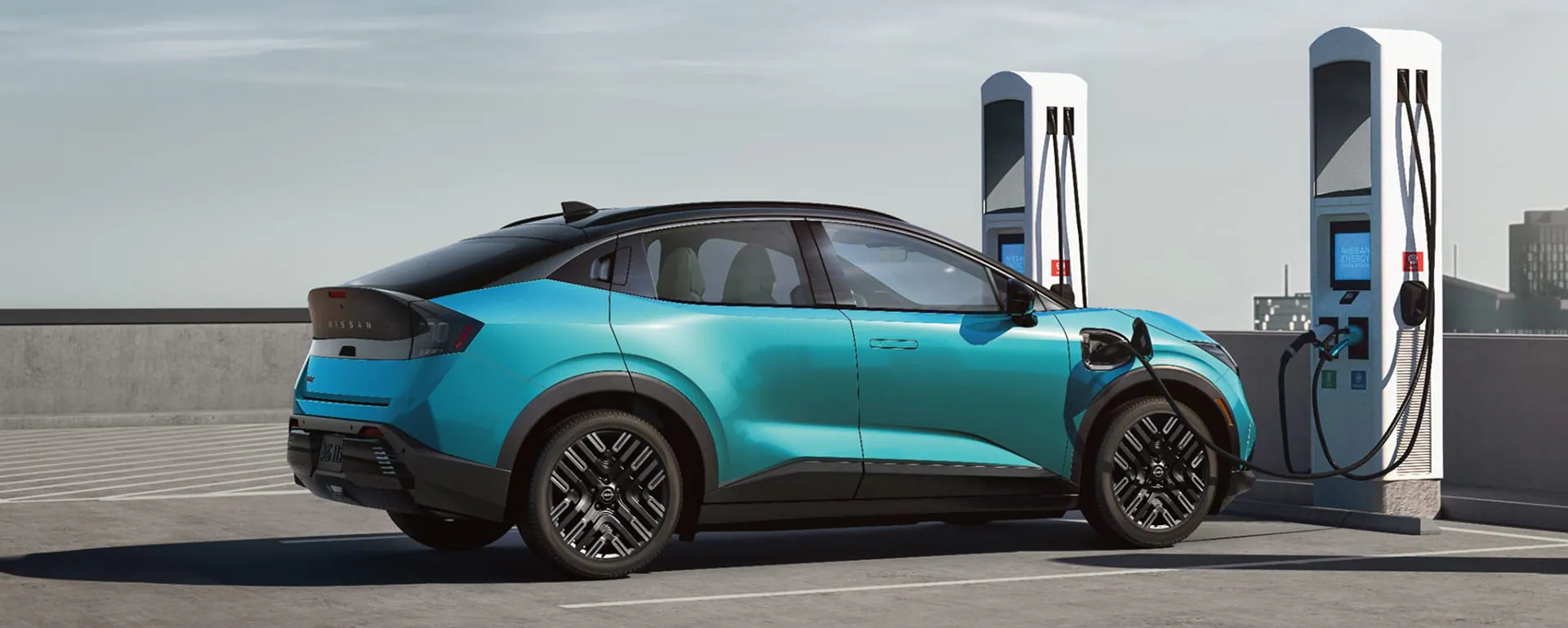 2026 Nissan LEAF in blue parked on a rooftop with modern building the background