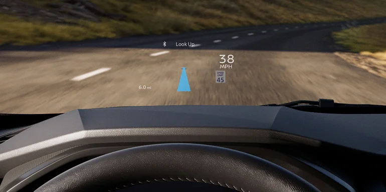 2026 Nissan Rogue Plug-in Hybrid interior view of a driver's hands on the steering wheels showing the digital dashboard, and mountain view out the front window.