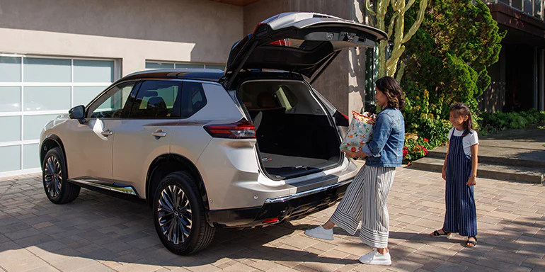 2026 Nissan Rogue parked in driveway as driver opens the Motion Activated Liftgate with her foot