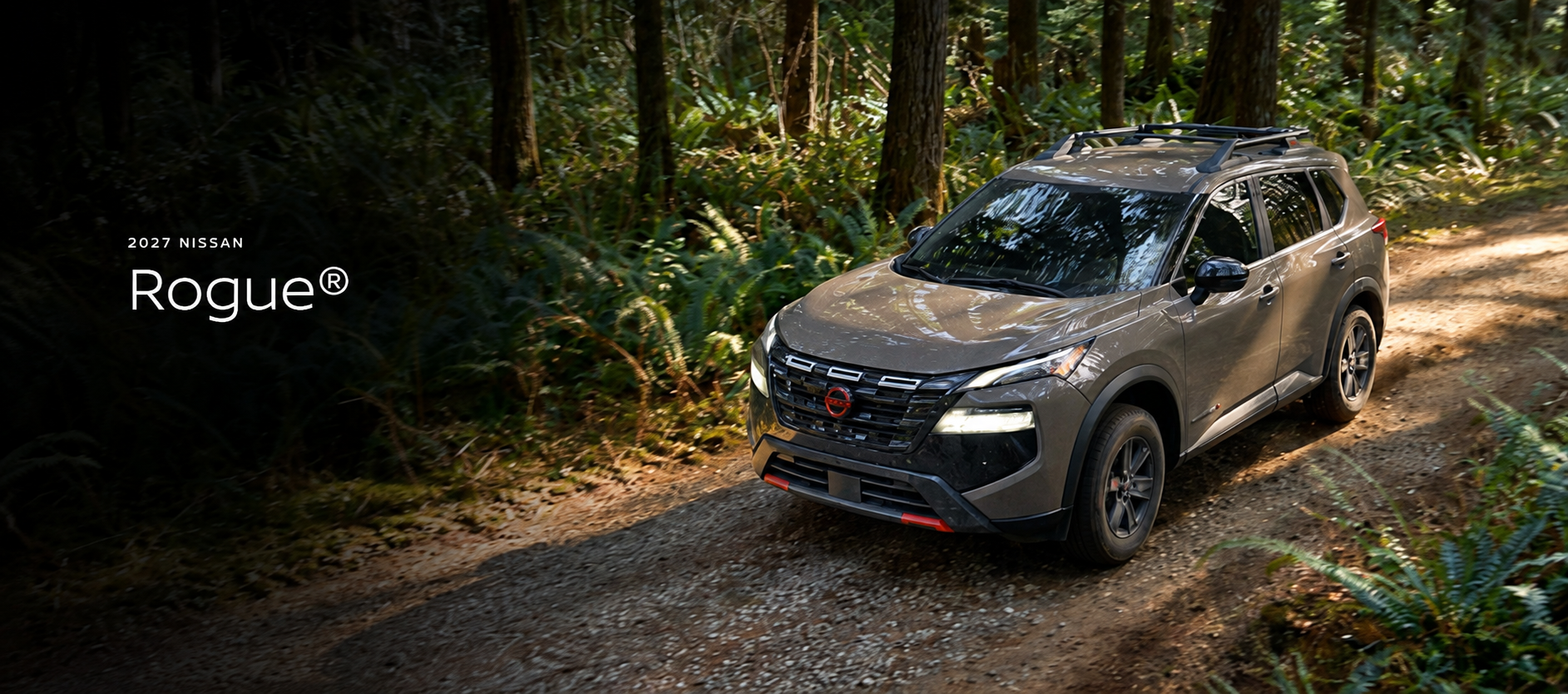 2027 Nissan Rogue driving on a forest dirt road