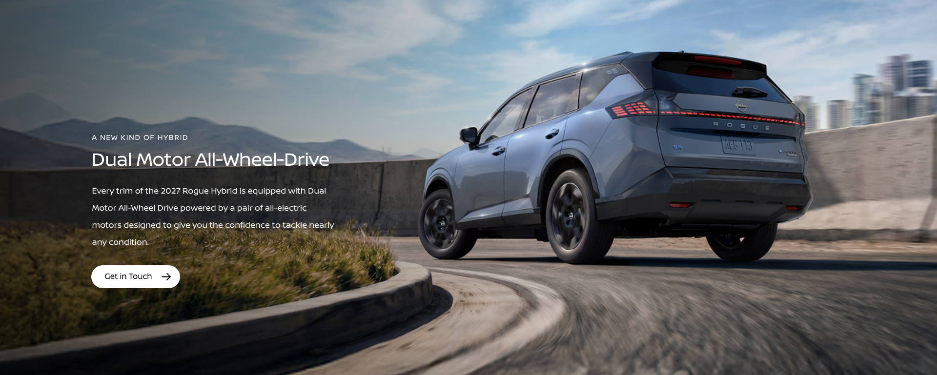 2026 Nissan Rogue driving through the desert scrub on a dirt road
