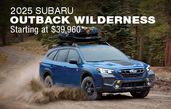 A blue Subaru Outback Wilderness off road SUV parked on a cliff overlooking mountains.