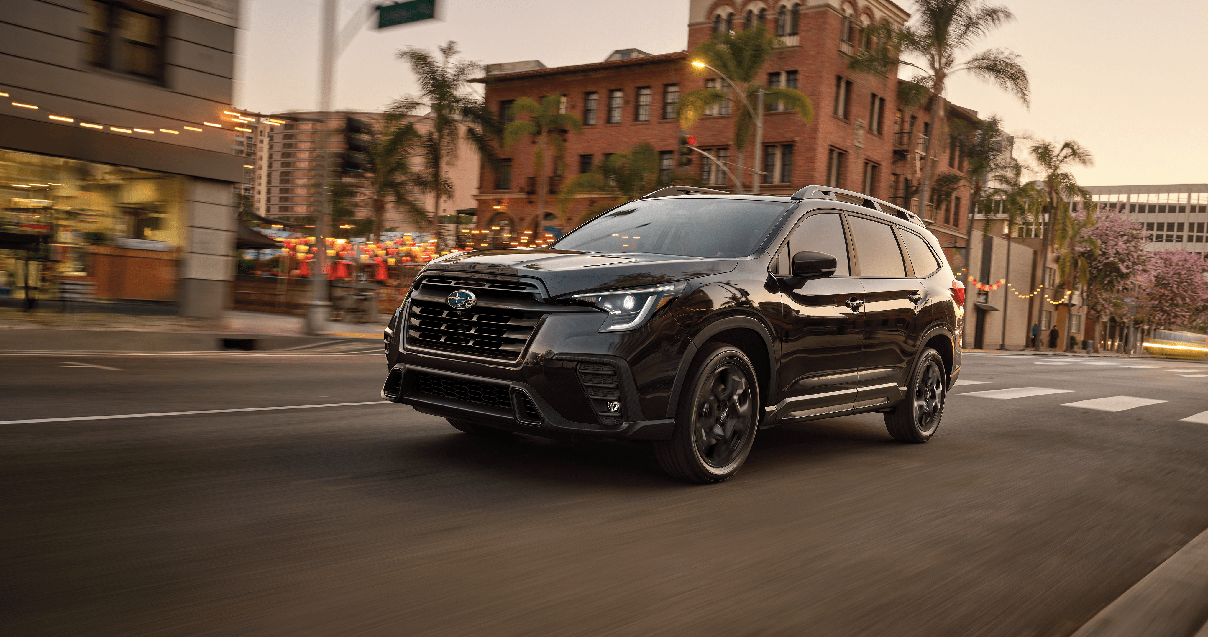 Black 2026 Subaru Ascent drives through a downtown neighborhood.