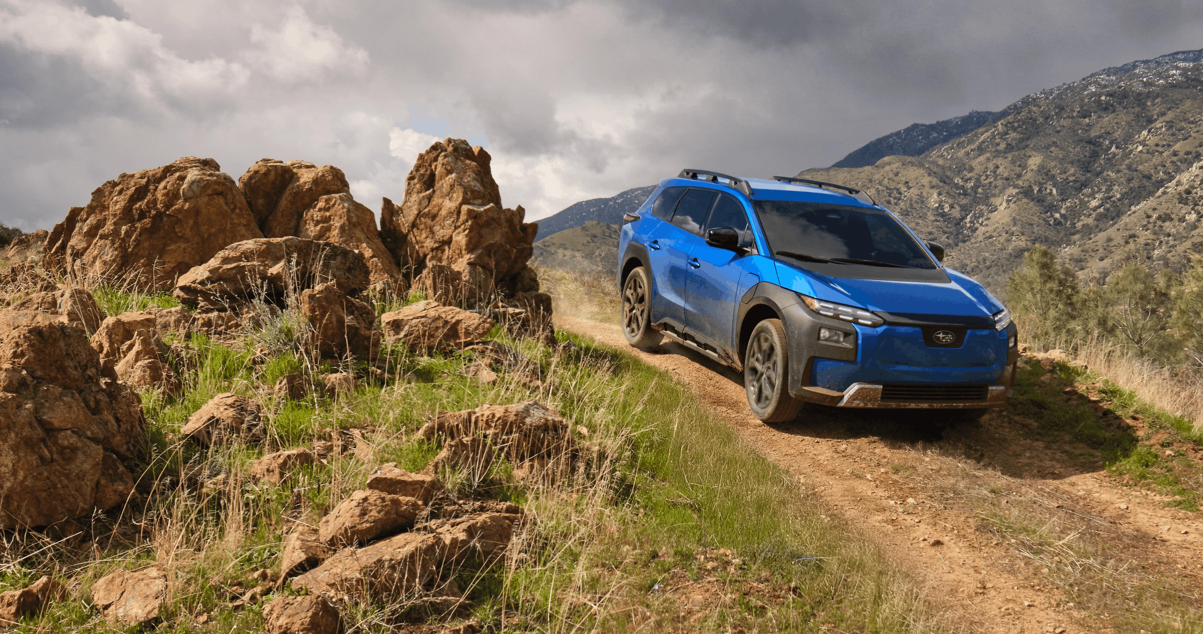 A 2026 Subaru Trailseeker in blue drives down an arid hill.
