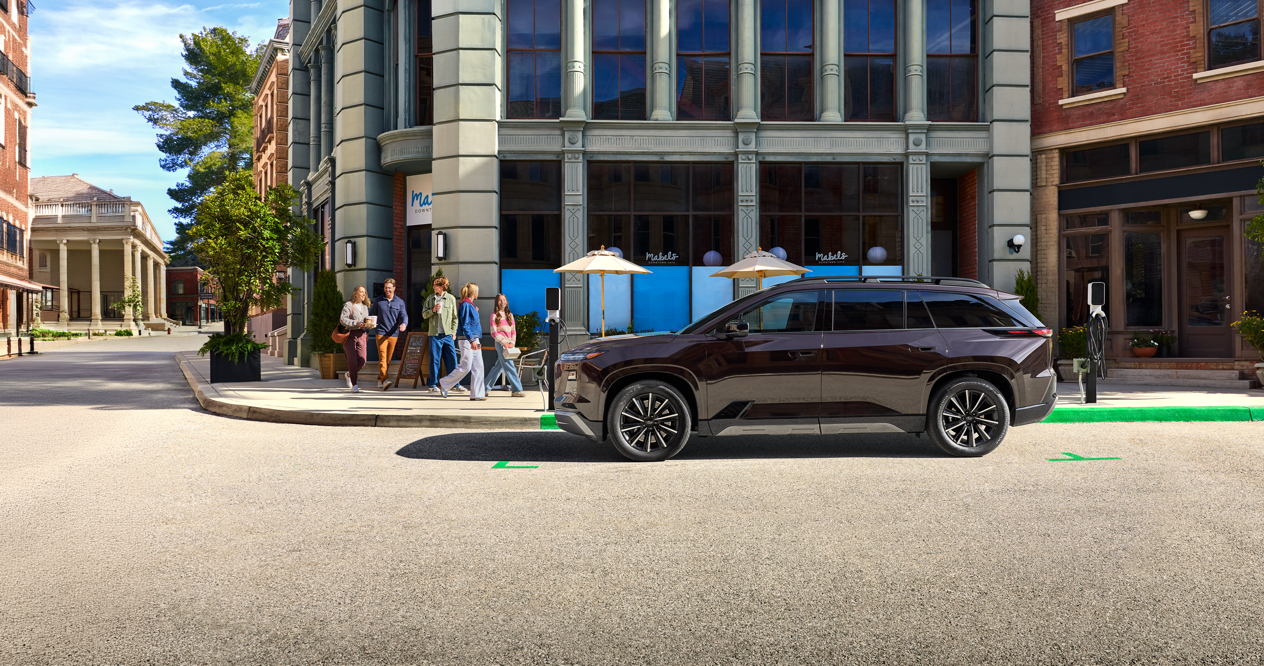 Subaru EV SUV parked at curb
outside of urban coffee shop.
