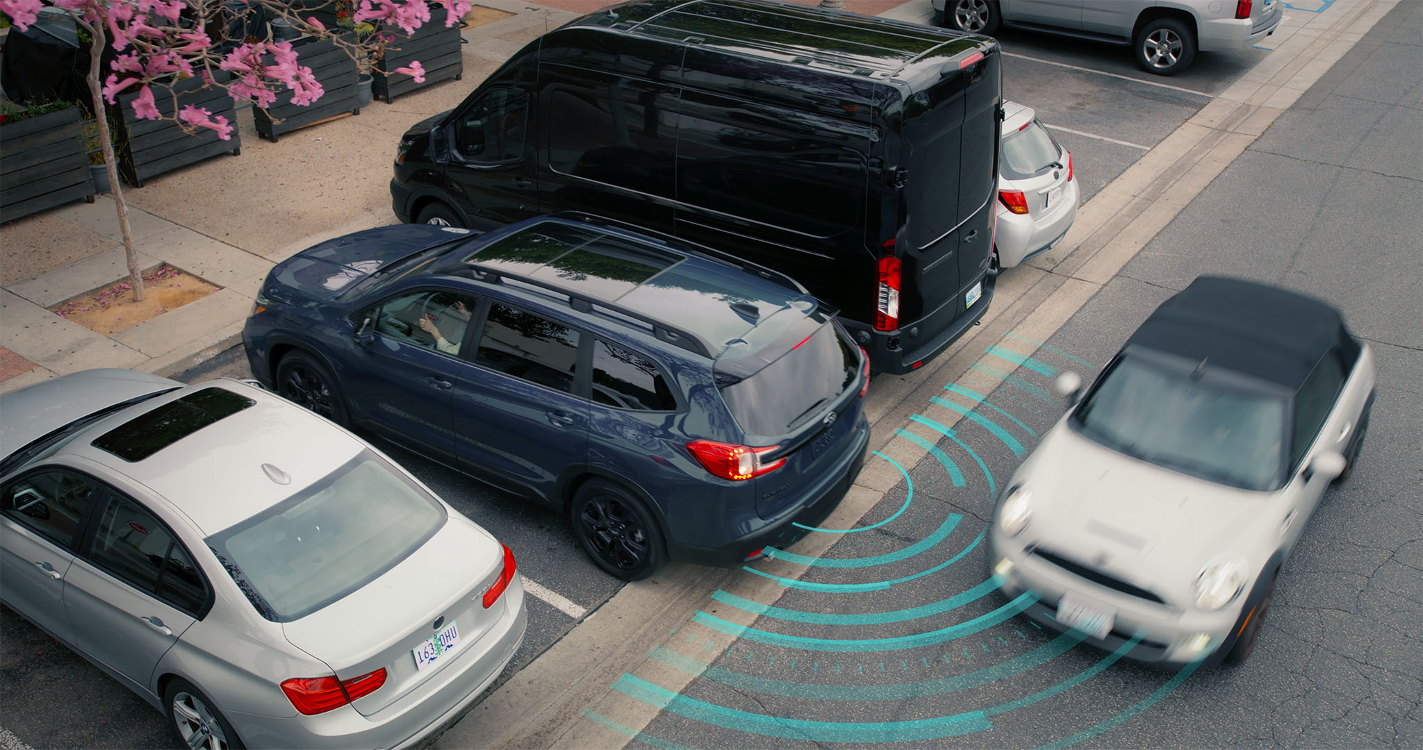 A Subaru projects an arcing line representing the Rear Cross-Traffic Alert.