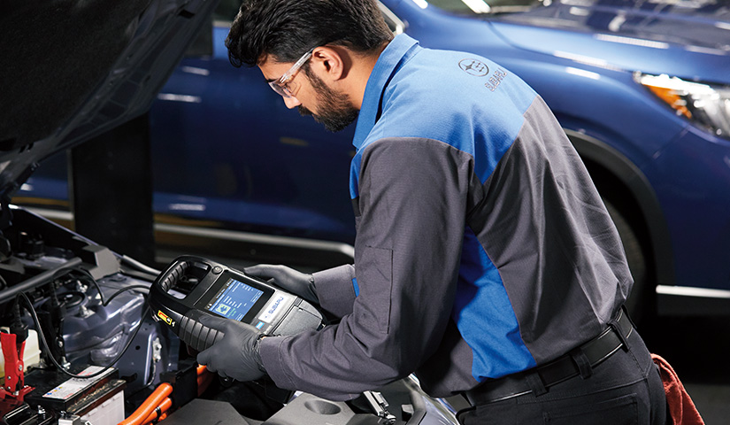 Service technician testing battery health of vehicle.