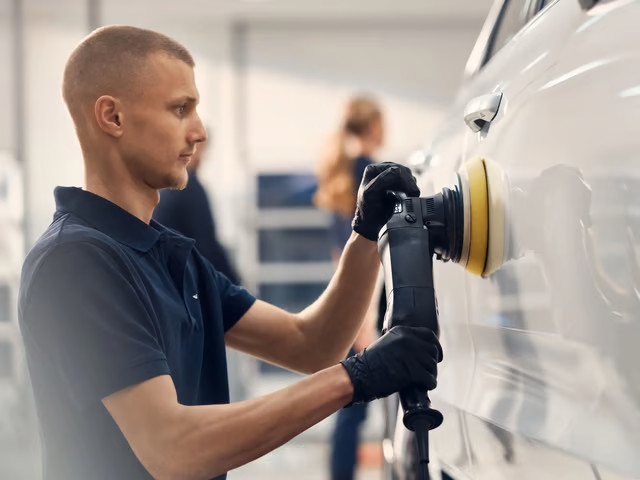 Service technician repairing paint on Volvo car