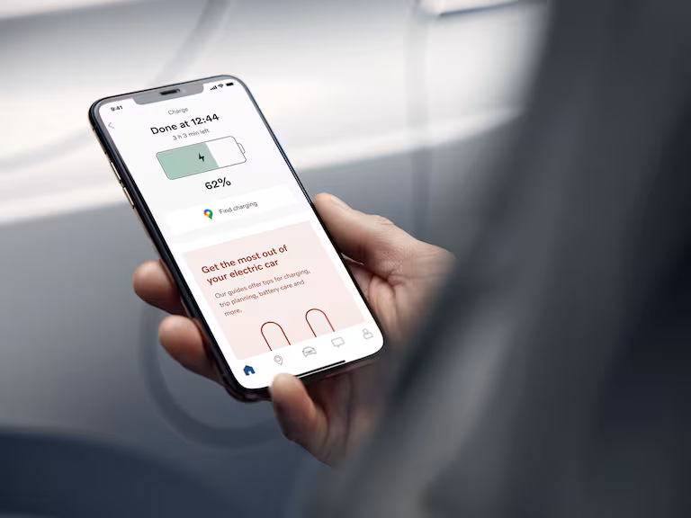 Close-up of a smartphone screen showing a Volvo driver the charging status of their car as it appears in the Volvo Cars app.